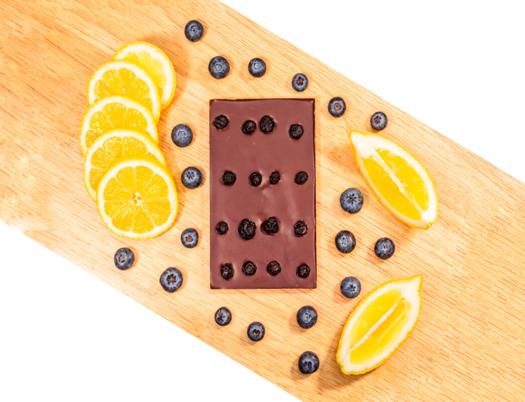 Chocolate bar surrounded by blueberries and slices of lemon